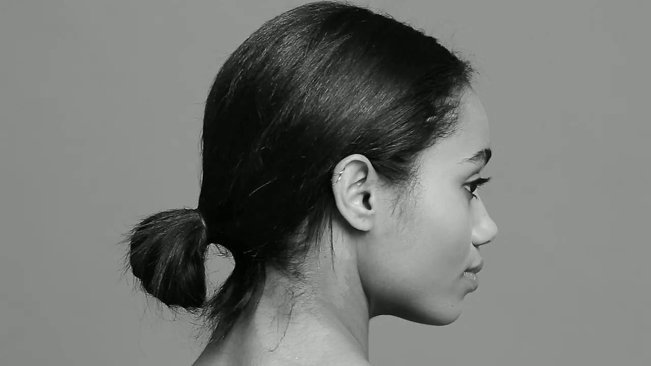 Model with a haircut featuring a sleek low bun.